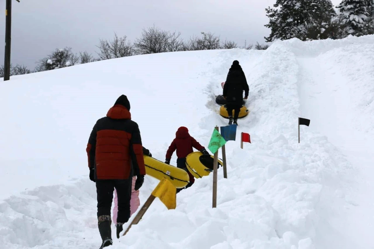 Abant&rsquo;ta k&ouml;yl&uuml;lerin hazırladığı pistte &ccedil;ocuklar şambrelle kaydı
