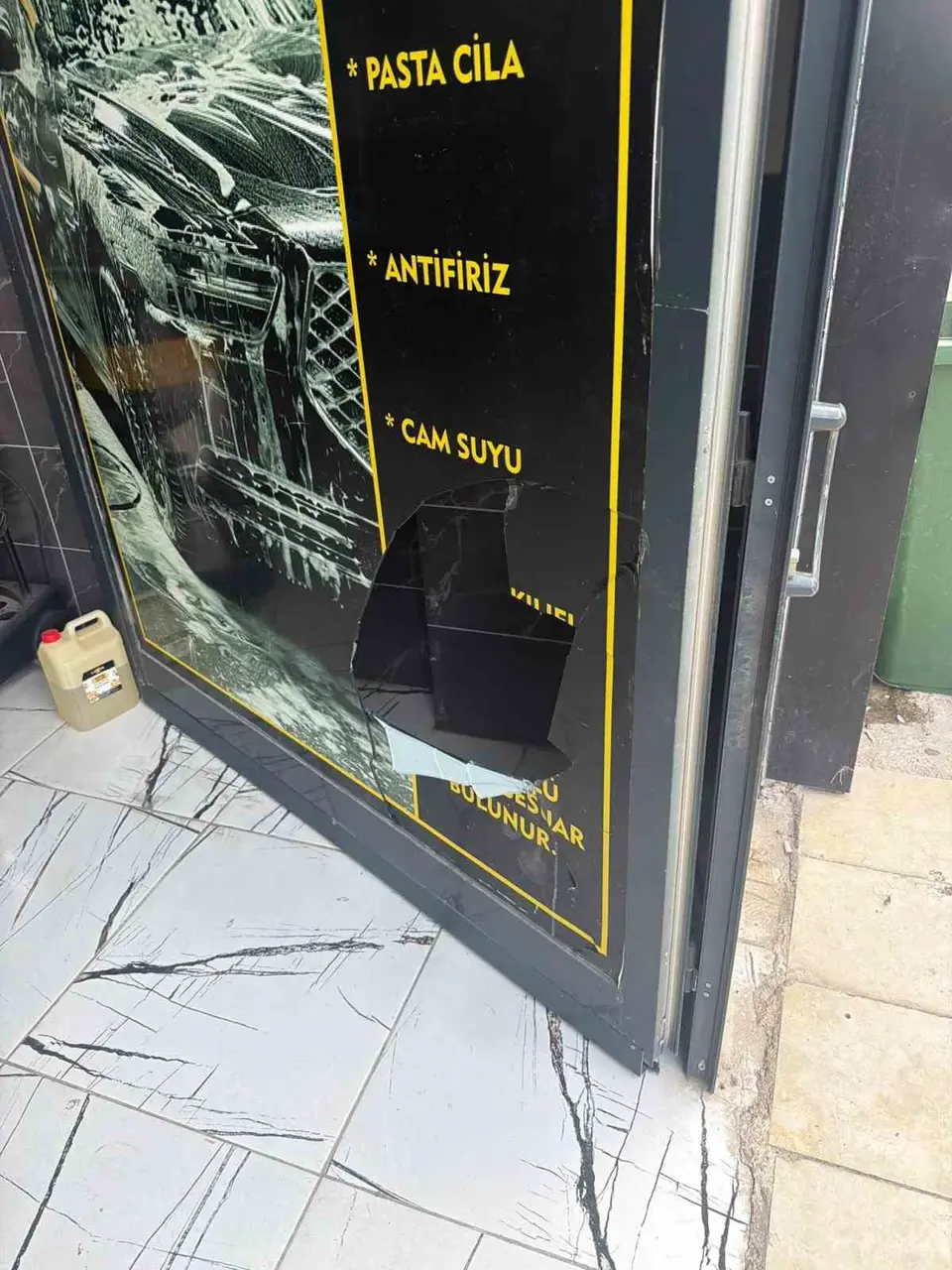 Ayakta duramayan alkollü şahsın iş yeri camını tekmelediği anlar kamerada