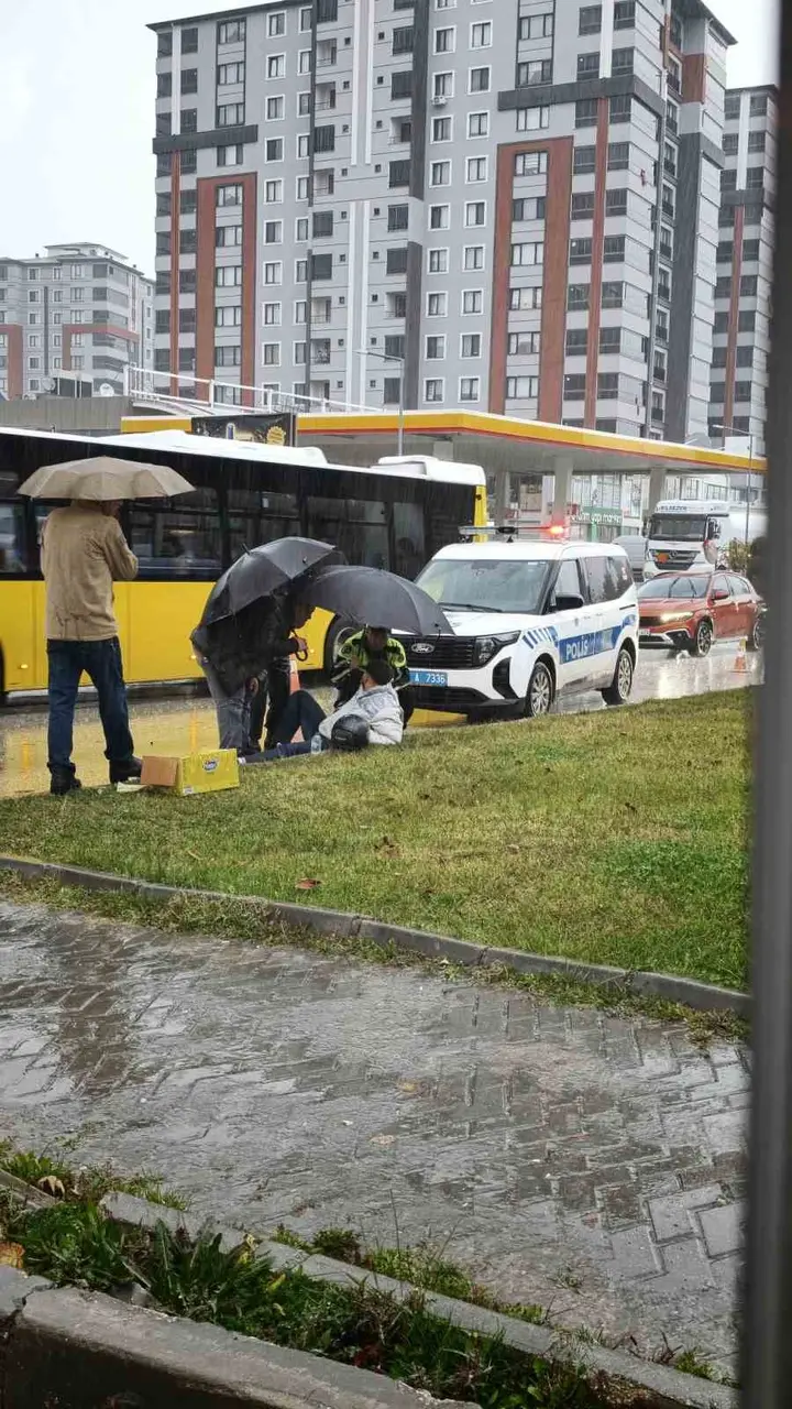Yağmur altında ıslanan yaralıya trafik polisi şemsiye tuttu