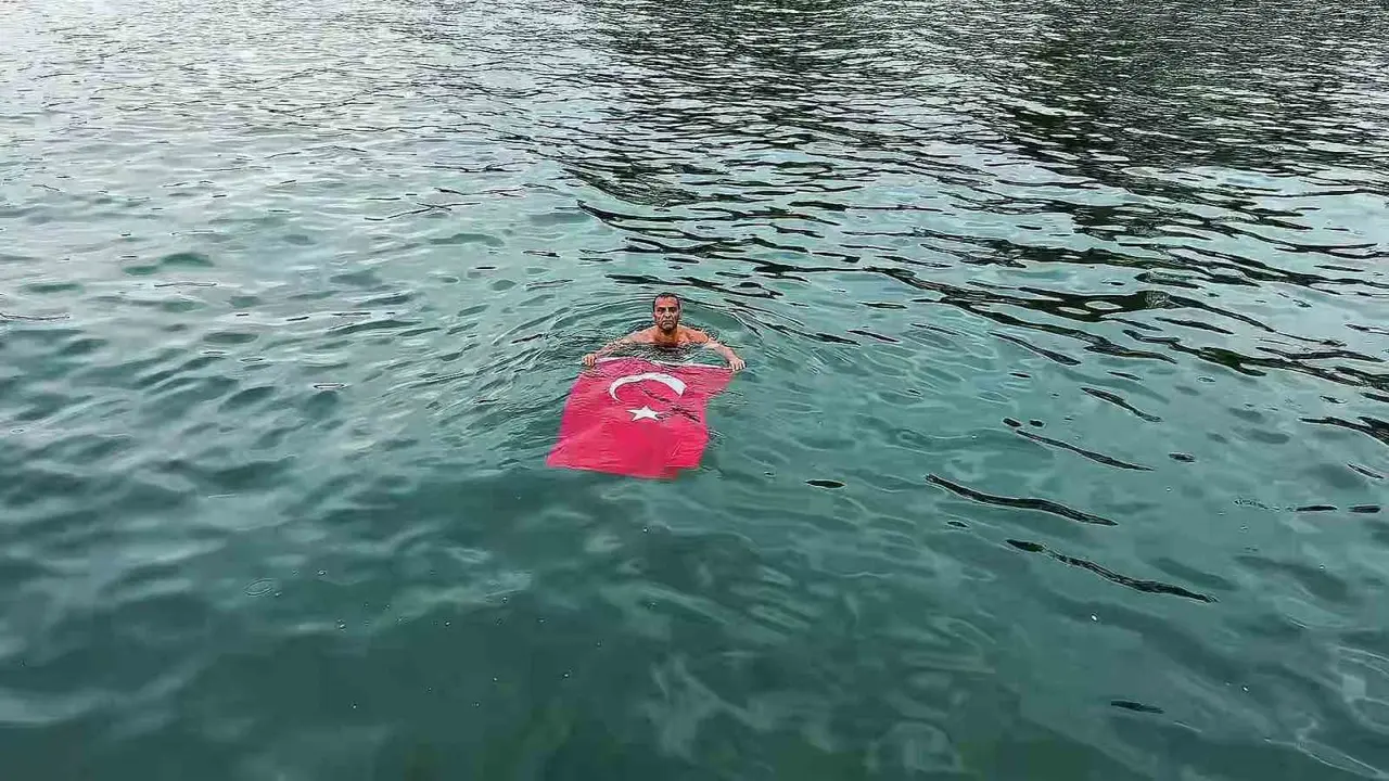 Soğuk ve yağışlı havaya aldırmadı, Türk bayrağıyla denize girdi