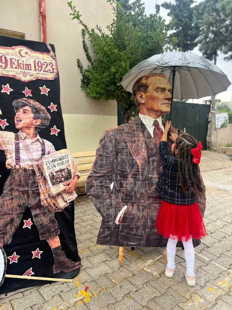 Yağmura aldırış etmeden Atasına şemsiye tutan küçük kızın davranışı yürekleri ısıttı