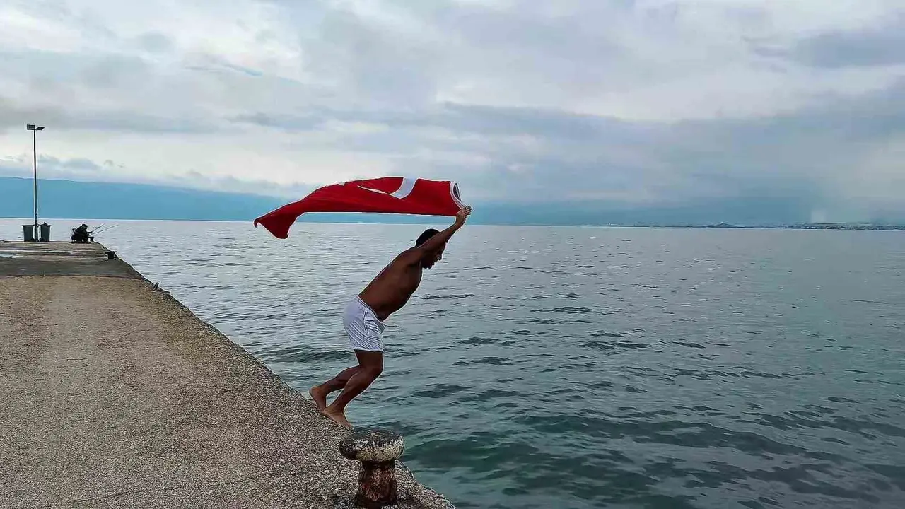 Soğuk ve yağışlı havaya aldırmadı, Türk bayrağıyla denize girdi