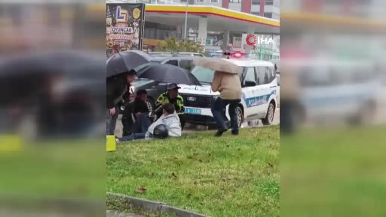 Yağmur altında ıslanan yaralıya trafik polisi şemsiye tuttu