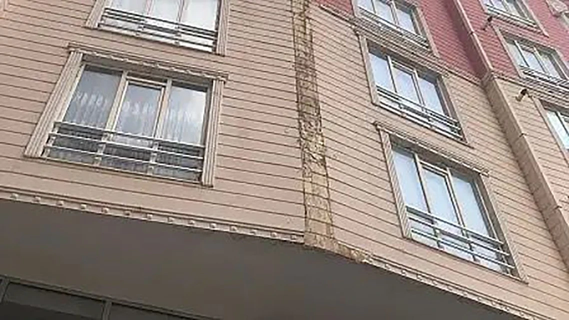 Apartmanın dış cephe kaplaması otomobilin &uuml;zerine d&uuml;şt&uuml;
