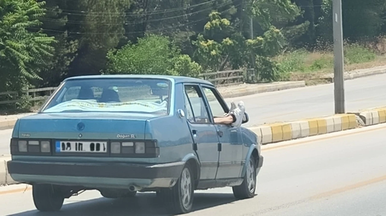 Ayaklarını camdan dışarı &ccedil;ıkartan yolcu trafiği riske attı
