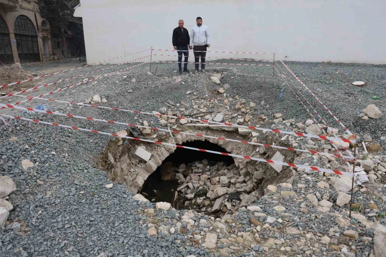 Depremde yıkılan binanın arazisinde yaşanan göçükle tarihi su kanalı ortaya çıktı
