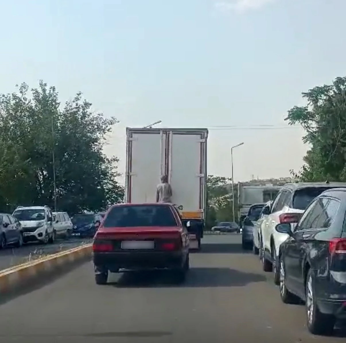 Diyarbakır’da kamyonetin arkasına tutunan şahsın tehlikeli yolculuğu kamerada
