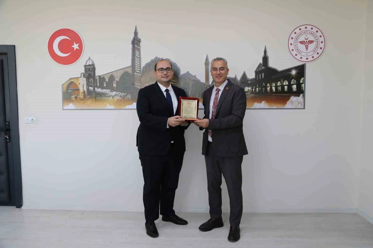 Diyarbakır Sağlık M&uuml;d&uuml;r&uuml; Emre Asilt&uuml;rk&rsquo;ten Dicle İl&ccedil;e Sağlık M&uuml;d&uuml;r&uuml; Uzm. Dr. Fırat K&ouml;se&rsquo;ye plaket
