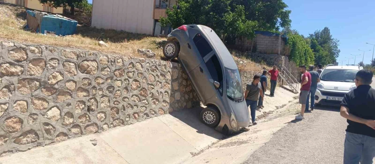 El freni &ccedil;ekilmesi unutulan otomobil istinat duvarından d&uuml;şt&uuml;: 2 yaralı
