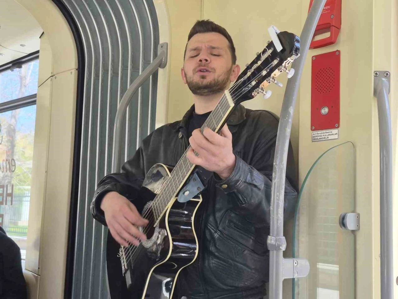Gen&ccedil; m&uuml;zisyen gitarıyla tramvayda konser verdi
