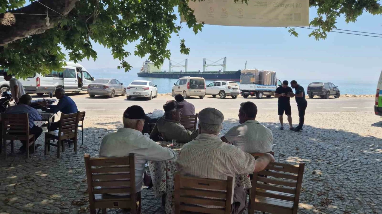 Karaya oturan gemiyi köy kahvesinden izliyorlar
