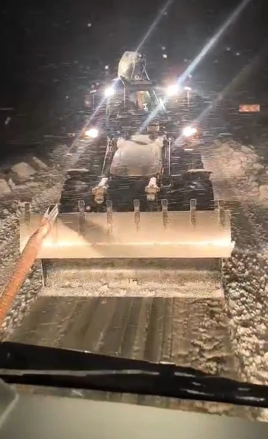 Karlı yolda mahsur kalan tır, iş makinesiyle kurtarıldı
