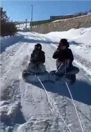Lastiği kızak yapıp ara&ccedil;la &ccedil;ektiler: &Ccedil;ocukların kar eğlencesi kameralara yansıdı
