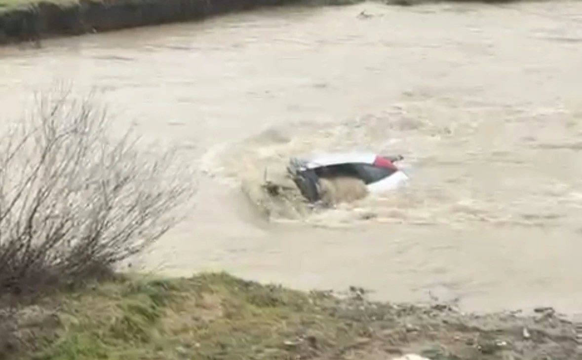 S&uuml;r&uuml;c&uuml; kıyıya &ccedil;ıktı, otomobil suda kaldı: Vatandaşlar halatla m&uuml;dahale etti
