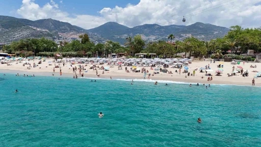 Alanya&rsquo;da hava sıcaklığı 30 dereceyi g&ouml;rd&uuml;, turistler sahile koştu
