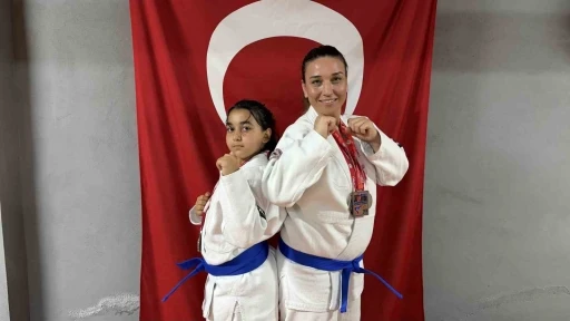 Anne ve kızı  minderde birlikte şampiyonluklara koşuyor
