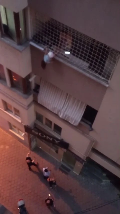 Balkon filesinde asılı kalan &ccedil;ocuğunu d&uuml;şmesin diye dakikalarca tuttu
