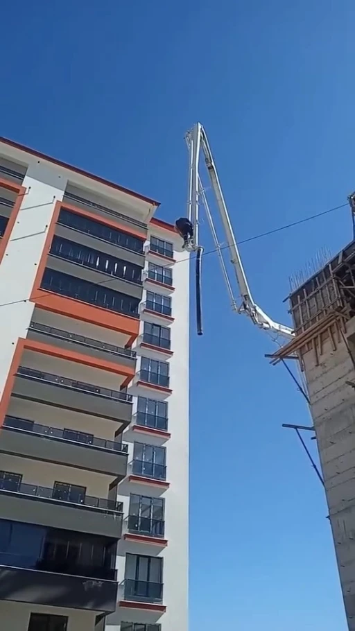 Beton pompasının üzerinde metrelerce yüksekliğe çıkan işçi, adeta ölüme meydan okudu

