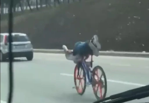 Bisikletin üzerinde uzanarak giden gençler trafiği tehlikeye attı
