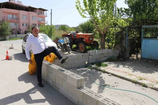 Evine girebilmek i&ccedil;in briketlerin &uuml;zerinden atlıyor
