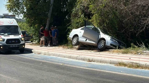 Kaldırıma çıkıp asılı kalan otomobildekiler kazayı burnu bile kanamadan atlattı
