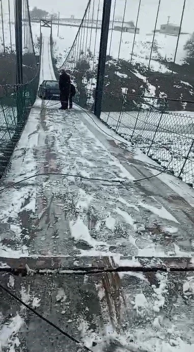 Kars&rsquo;ta asma k&ouml;pr&uuml;de korku dolu anlar: Otomobil buzda kayarak asılı kaldı
