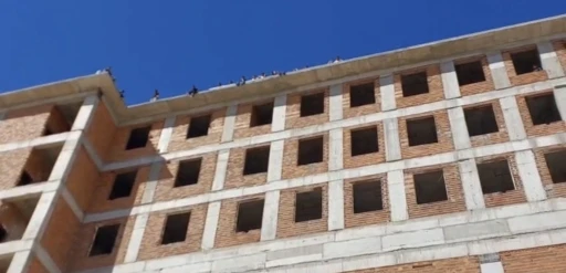 Maaşlarını alamayan işçiler binanın tepesine çıktı
