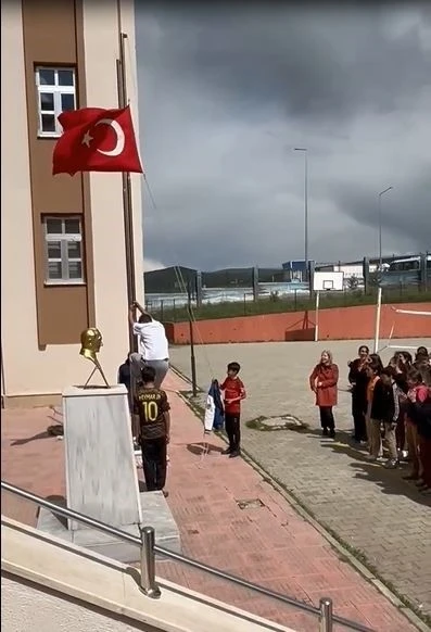 Okul önünde direğe dolanan bayrağı tırmanarak çözdü
