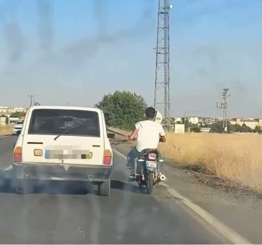 Otoyolda tehlikeli yolculuk: Motosiklet, otomobil kemerine tutunarak ilerledi
