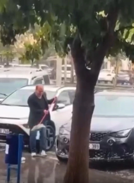 Sağanak yağmur altında arabasını yıkadı
