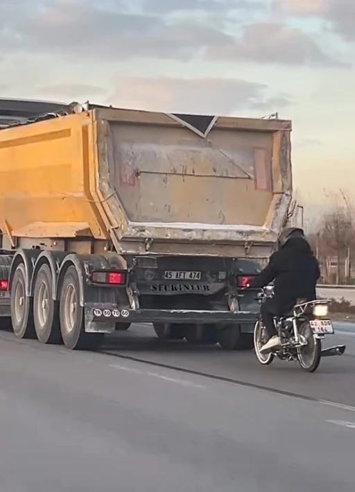 Seyir halindeki tırın peşinde motosikletli tehlikeli yolculuk
