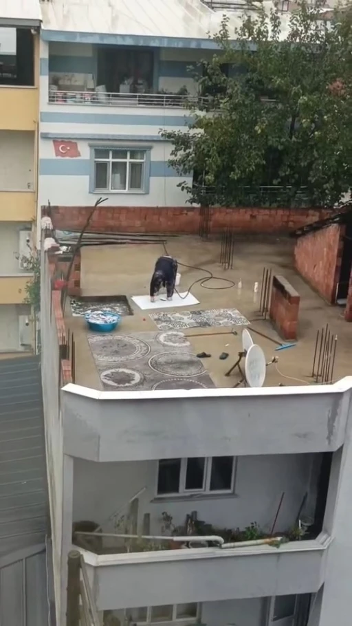 Yağmurlu havada çatıda halı yıkadı, görenler şaştı kaldı
