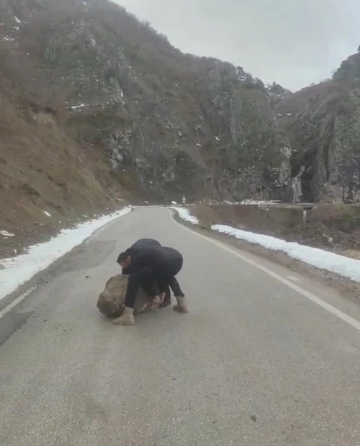 Yola d&uuml;şen kayayı otomobilleriyle &ccedil;ektiler
